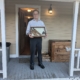 man holding case with some artifacts on a porch